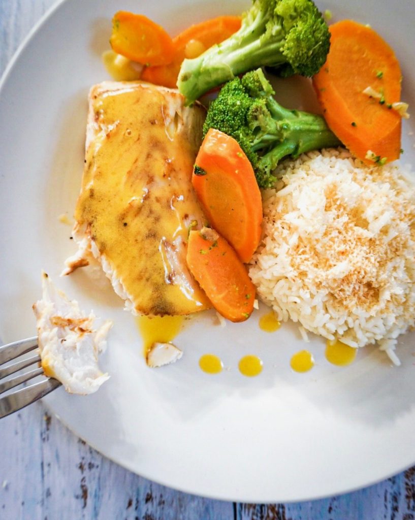 close up fish filet with passionfruit sauce, veggies and rice