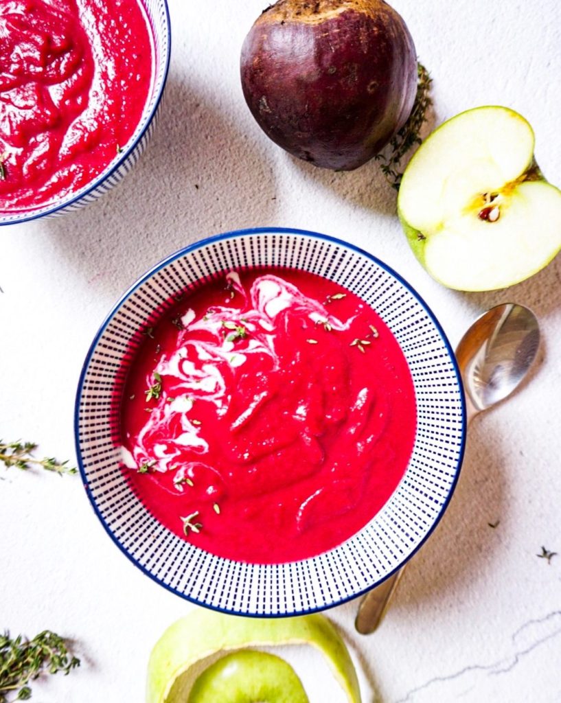 Healthy beetroot soup close up with apples, beetroot and thyme