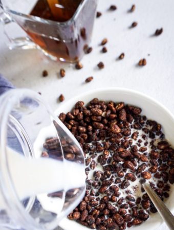 close up milk poured on cocoa puffs