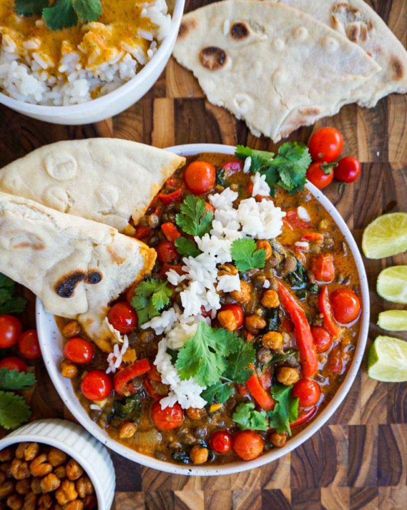 curry with naan and lime wedges