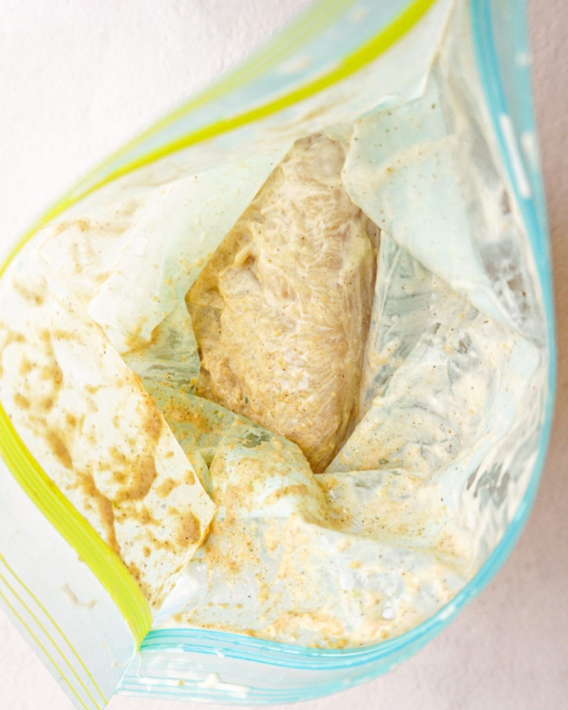 chicken marinating in a ziplock bag