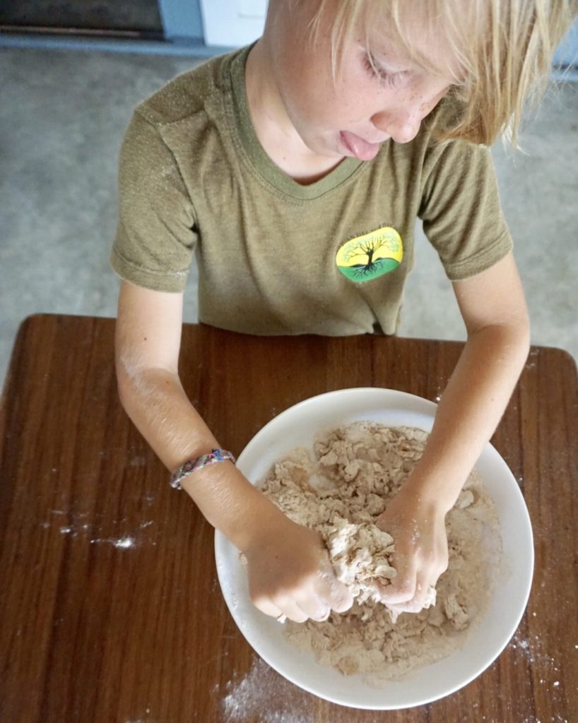 kid kneading pizza dough