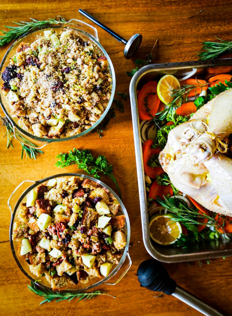 two types of stuffing in casseroles next to a stuffed turkey