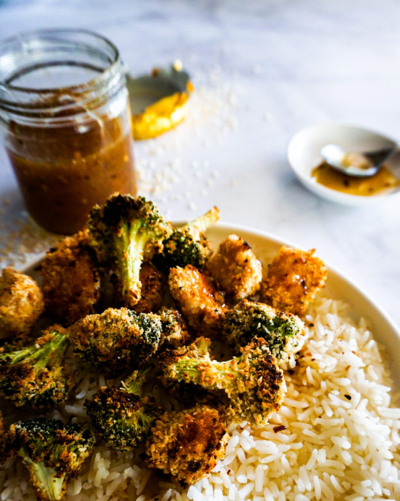 plate of broccoli and chicken coconut popcorn with rice and sweet chili sauce close up