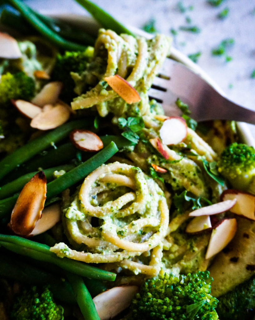 green spaghetti alfredo with veggies close up