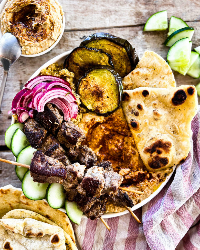 souvlaki hummus bowl with grilled eggplant and naan bread