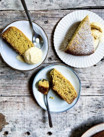 Slices of olive oil orange cake on plates with ice cream