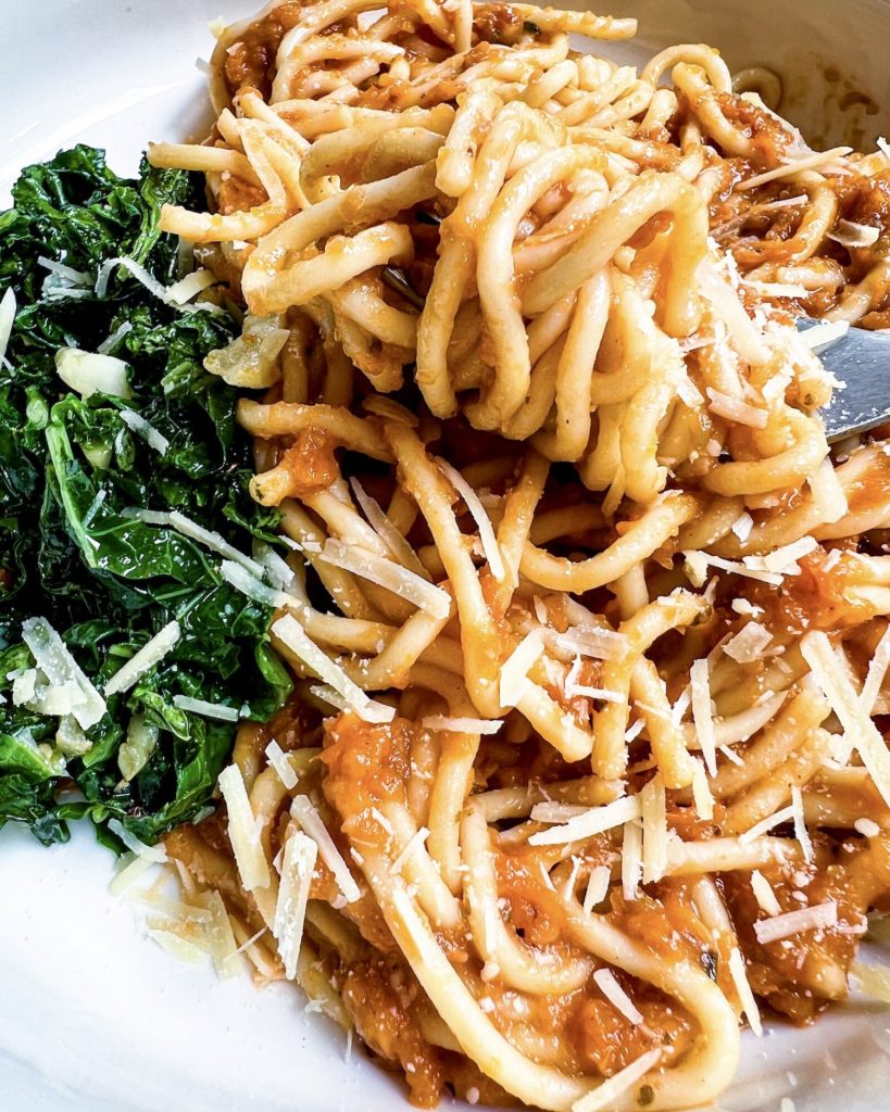 a fork full of pasta with sauce close up