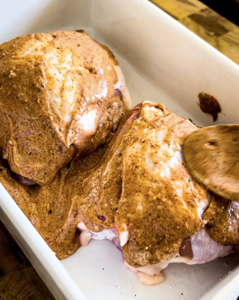 spreading marinate onto the chicken