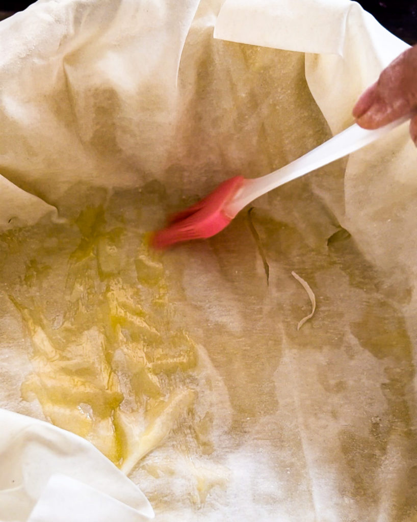 brushing melted butter on the phyllo dough