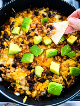 chicken enchilada dip topped with avocado