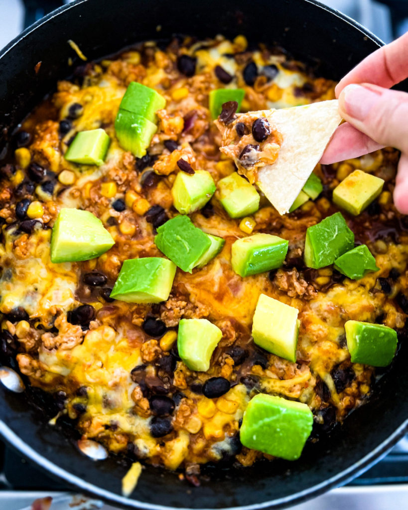 chicken enchilada dip topped with avocado