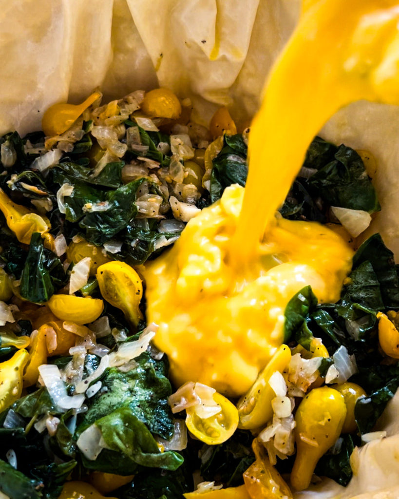 pouring the egg mixture on top of the spinach mixture