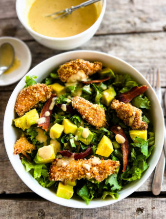 chicken finger salad in a bowl with dressing on the side