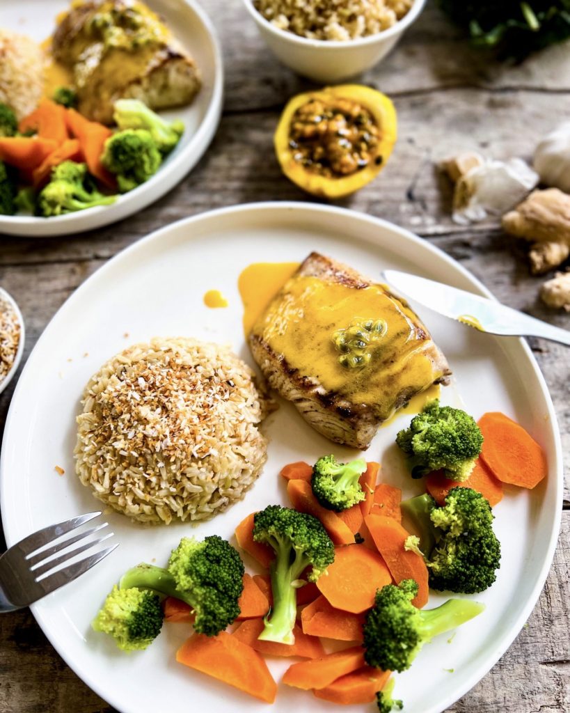 2 plates of fish with passionfruit sauce, veggies and rice close up